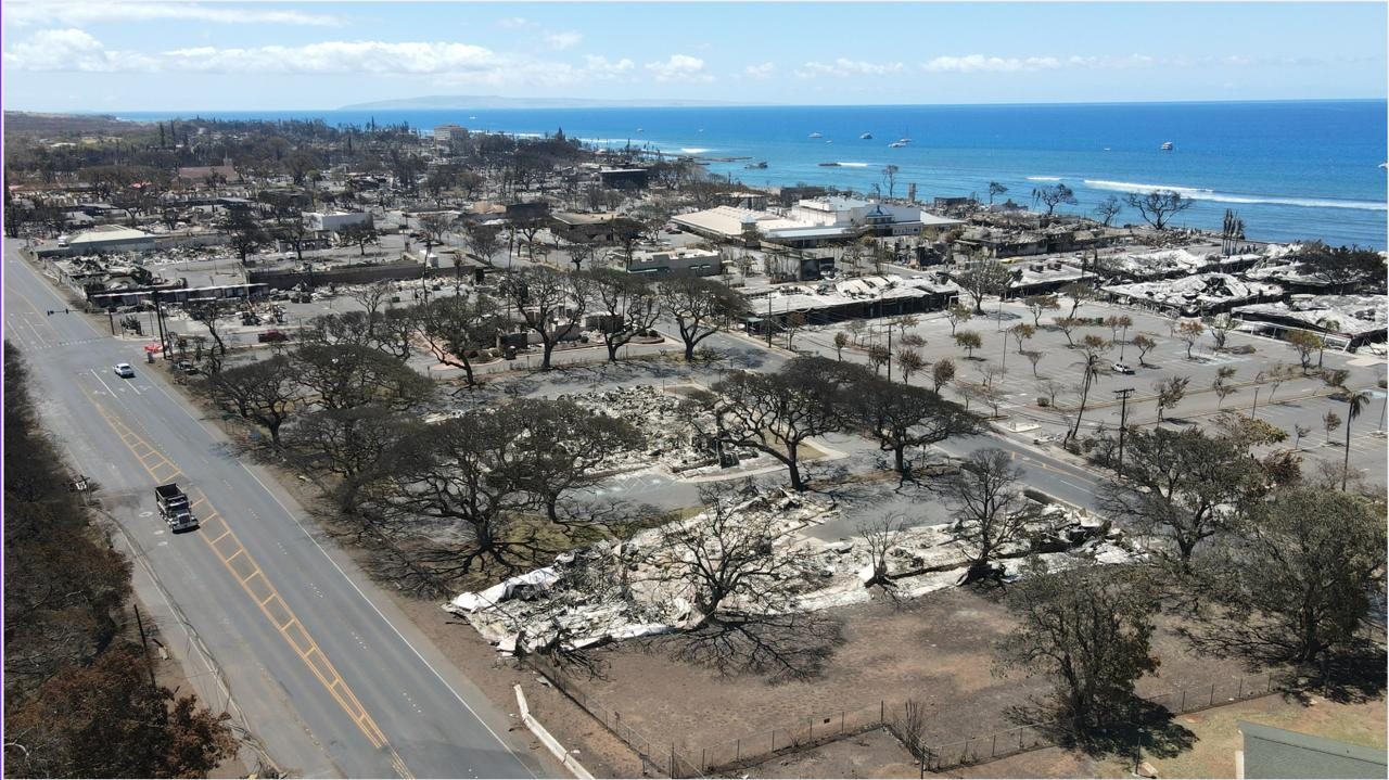 Aerial view of Lahaina after the 2023 fire — burned blocks stretching to the ocean
