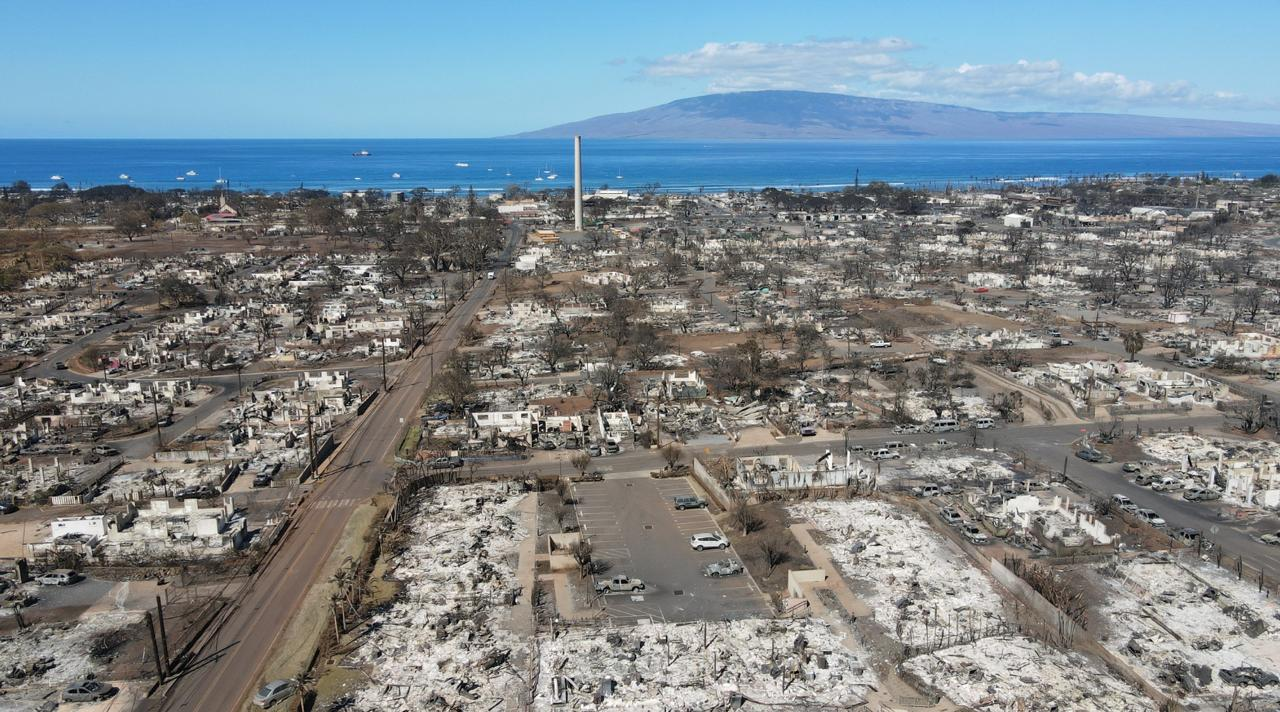 Aerial view of Lahaina after the 2023 fire — burned blocks stretching to the ocean